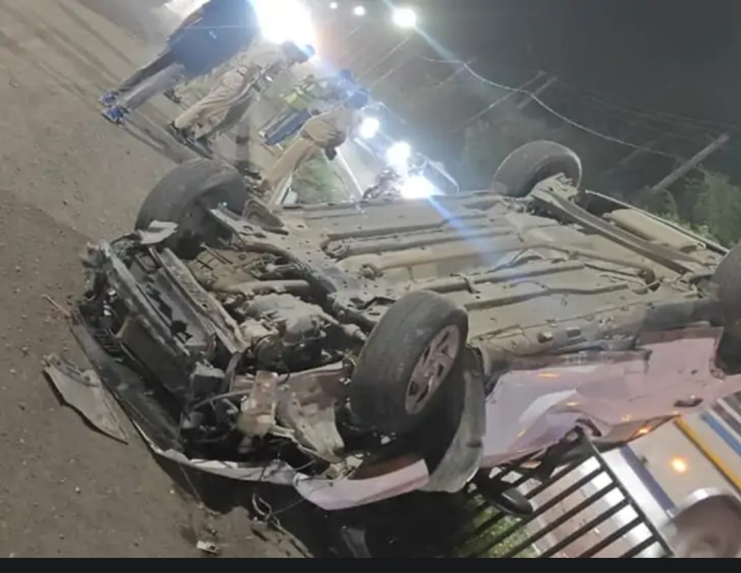 Car skidded after sudden braking, crashed through the railing, and overturned on the highway.