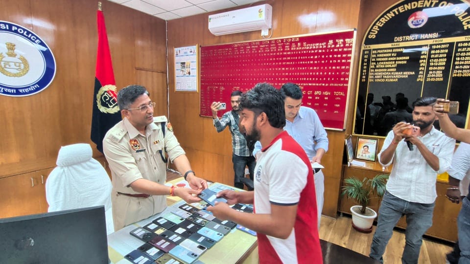 हांसी मोबाइल मालिक को फोन वापस सौंपते हुए एसपी विनोद कुमार। पुलिस