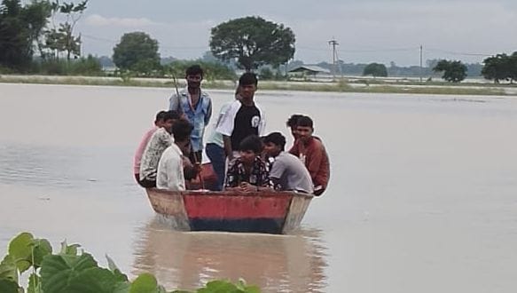 खैरी शीतल प्रसाद के नकोलडीह टोले में रास्ते में पानी भरा होने से लोग नाव की सहायता से कर रहे आव