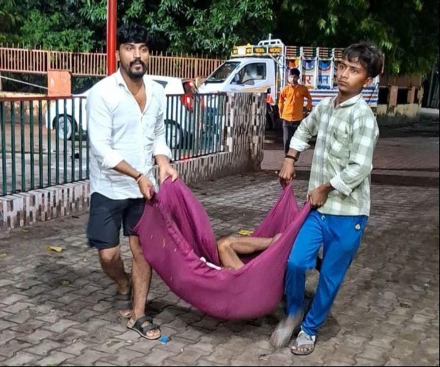 मेडिकल कॉलेज की इमरजेंसी में गठरी की तरह बुजुर्ग को चादर में ले जाते परिजन। - संवाद