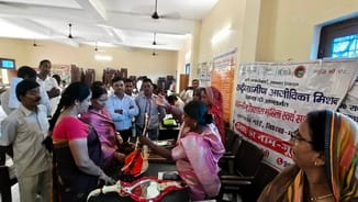 मरदह विकासखंड सभागार में लगी प्रदर्शनी में लोगों को अपने उत्पादों की जानकारी देतीं स्वयं सहायता