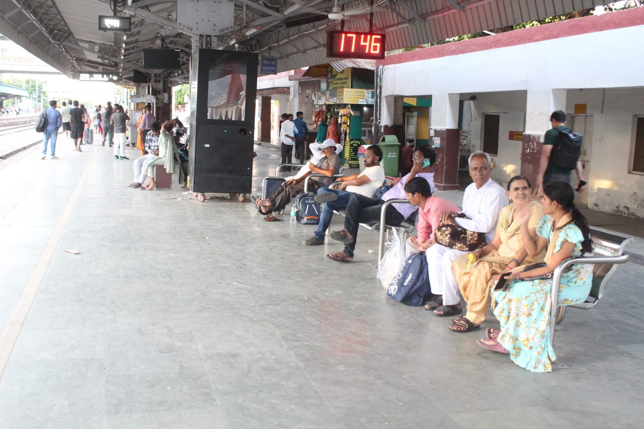 रेलवे स्टेशन पर ट्रेन का इंतजार करते यात्री। संवाद
