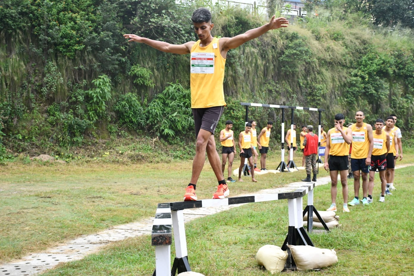 सिंथेटिक ट्रैक अणु में थल सेना की अग्निवीर भर्ती के दौरान जिग-जैग बैलेंस लगता युवा। स्रोत जनसंप
