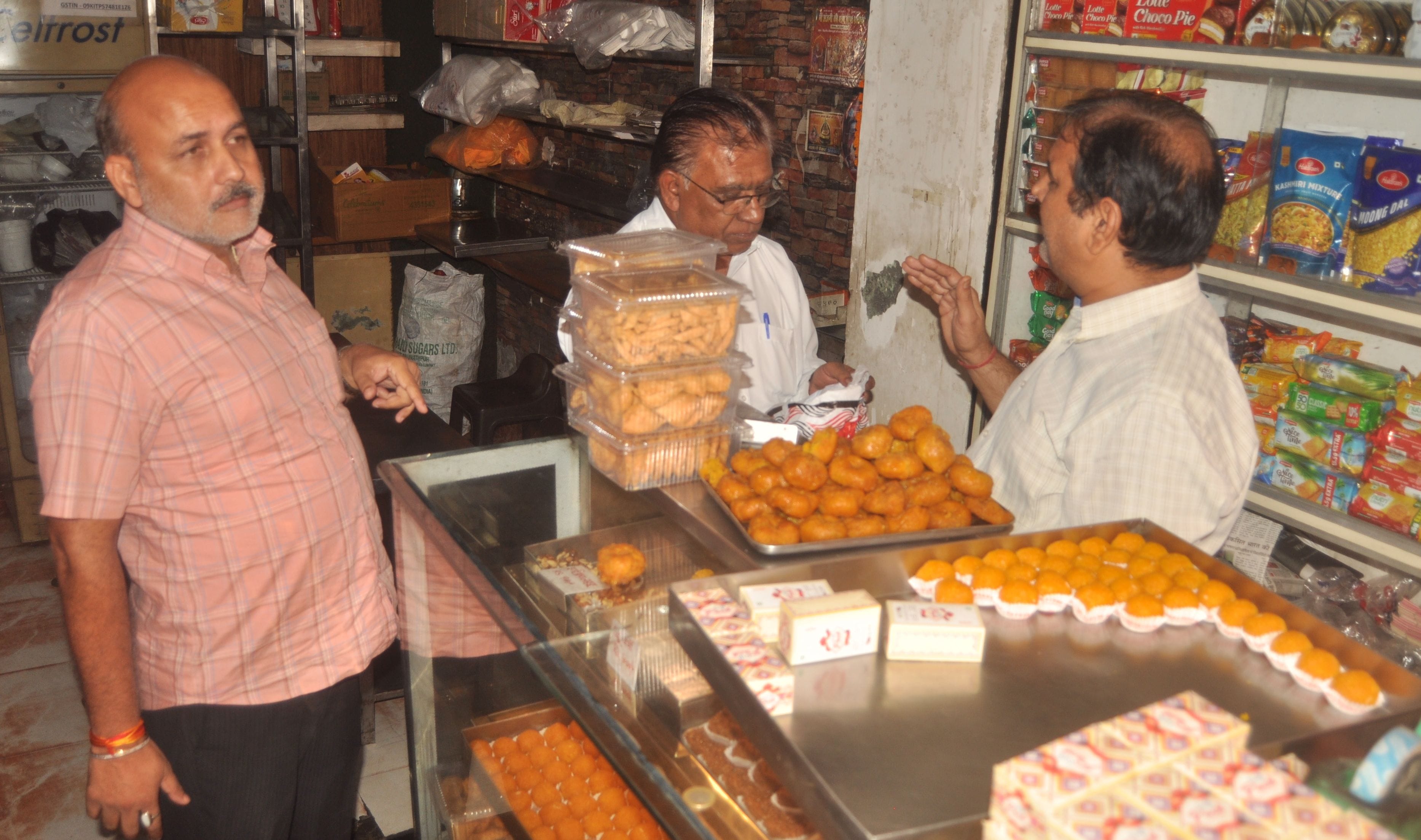 तहसील चौराहा स्थित मिठाई की दुकान पर दुकानदार को खराब मिठाई दिखाते ग्राहक। संवाद