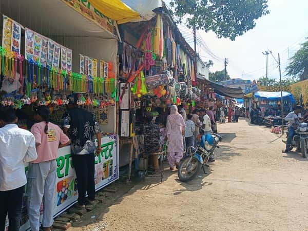धूप निकलने के बाद मेला परिसर में लगी दुकानों पर खरीदारी करते ग्राहक। संवाद