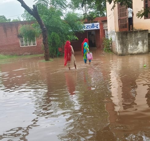 उपतहसील परिसर में बारिश के बाद भरा पानी, इसी पानी से होकर कार्यालय पहुंचती महिला।