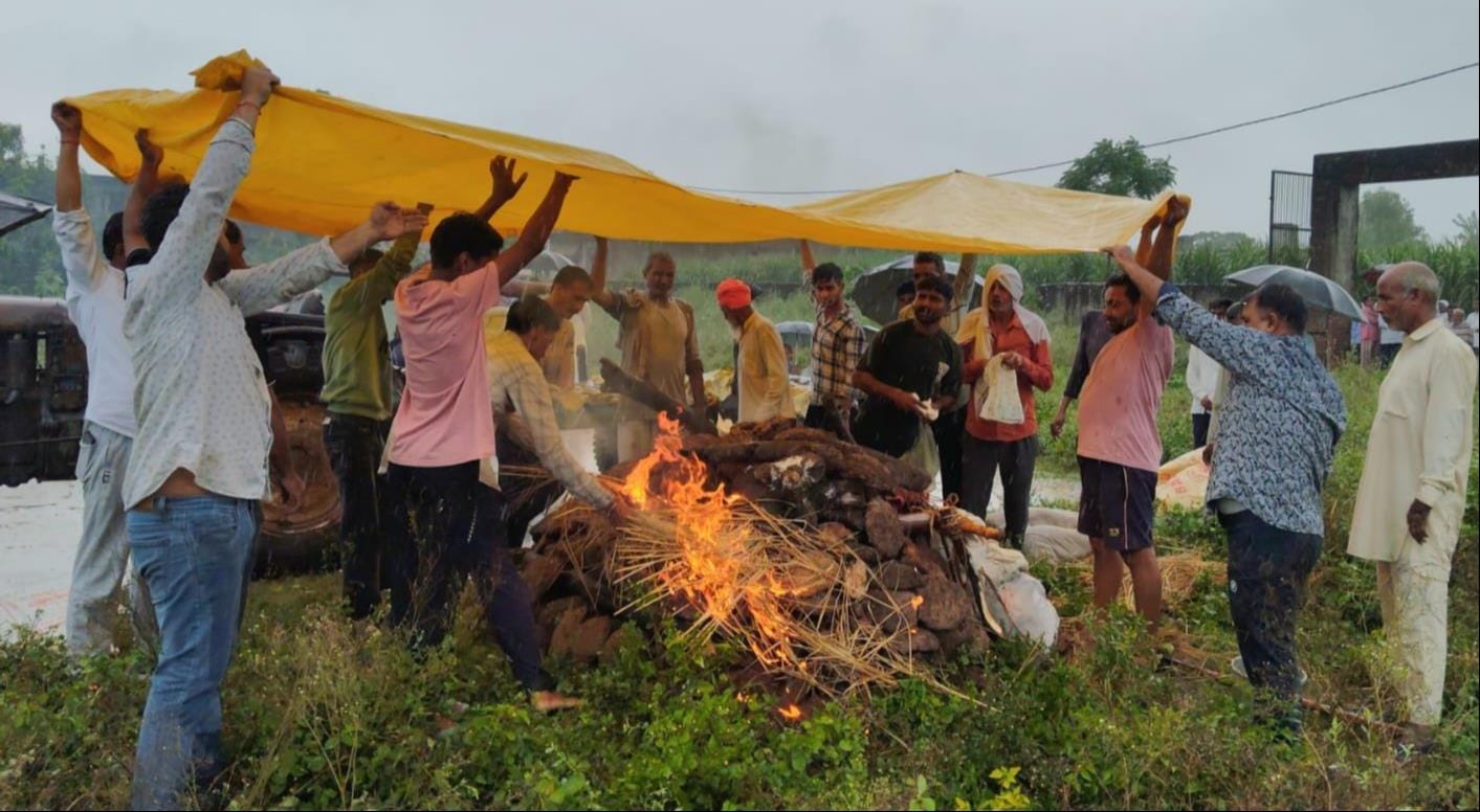 बेबसी... बाबरी में बारिश के दौरान तिरपाल डालकर अंतिम संस्कार करते ग्रामीण। संवाद