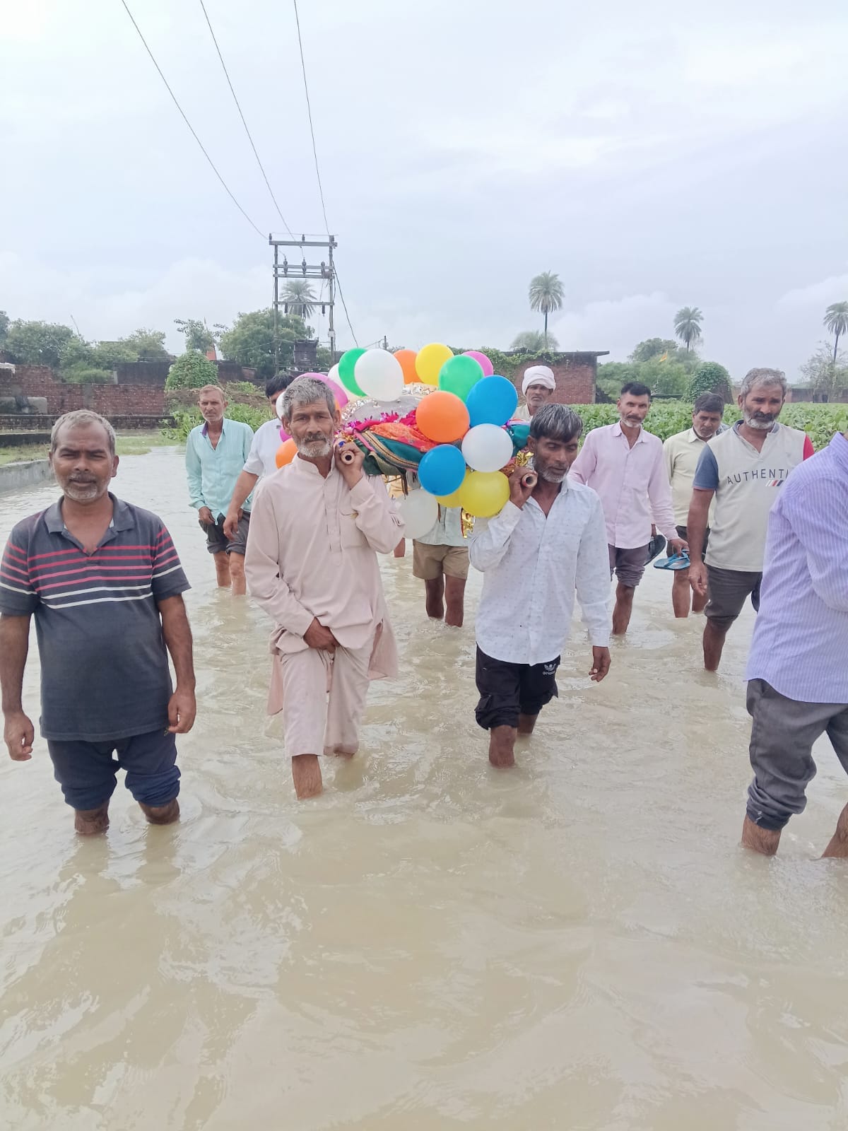 Funeral procession wades through water; questions raised about arrangements.