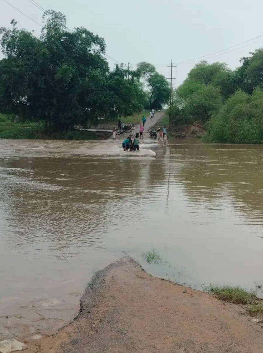 Water flows over the Valmiki river causeway; contact with ten villages cut off.