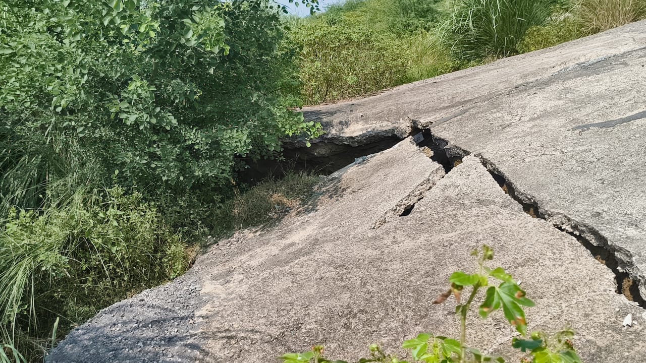 मार्ग के किनारे आईं दरारें।