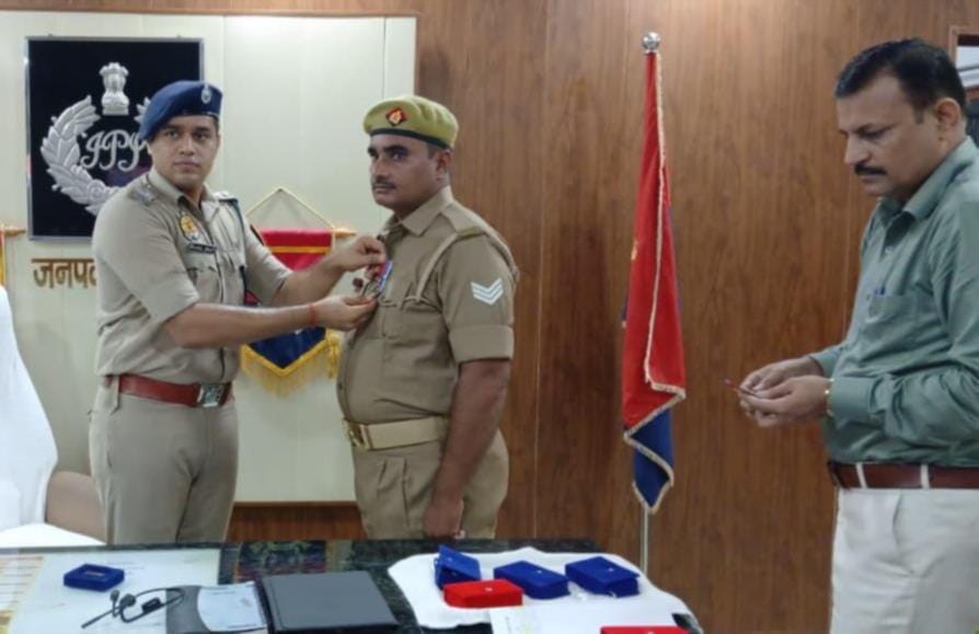 पुलिसकर्मी को प्रशंसा चिन्ह लगाते एसपी।