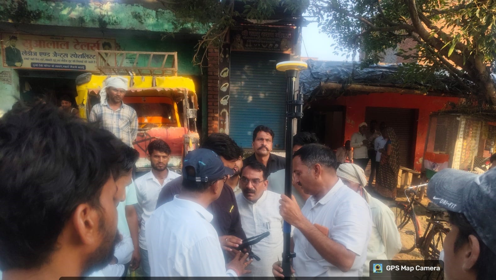 दुकानों की रोबर मशीन से पैमाइश करती राजस्व टीम। स्रोत-प्रशासन।