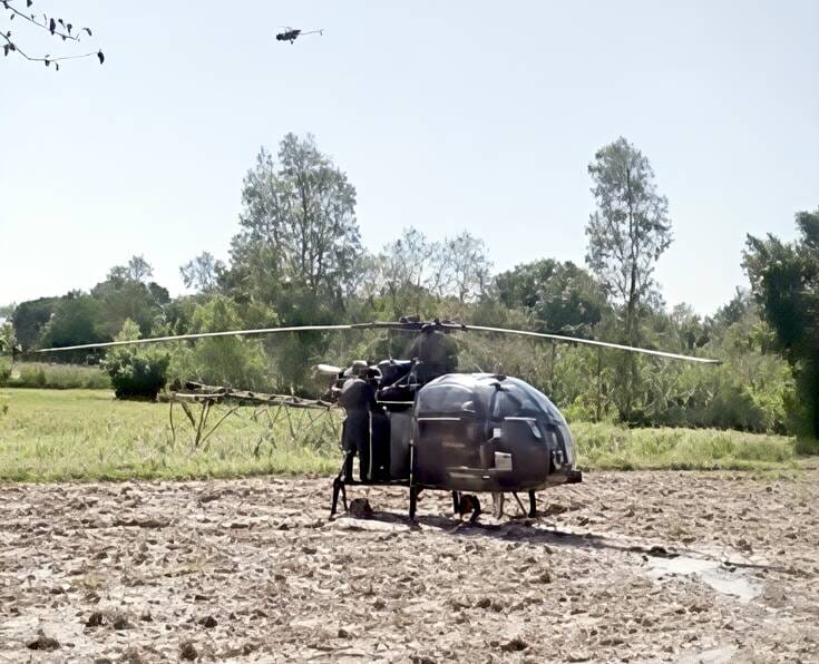 Army helicopter lands in muddy field