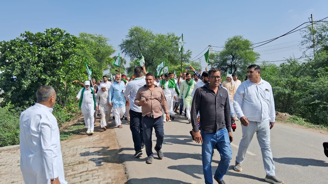Farmers march towards high-tension line; stage sit-in in front of barricades after being stopped.