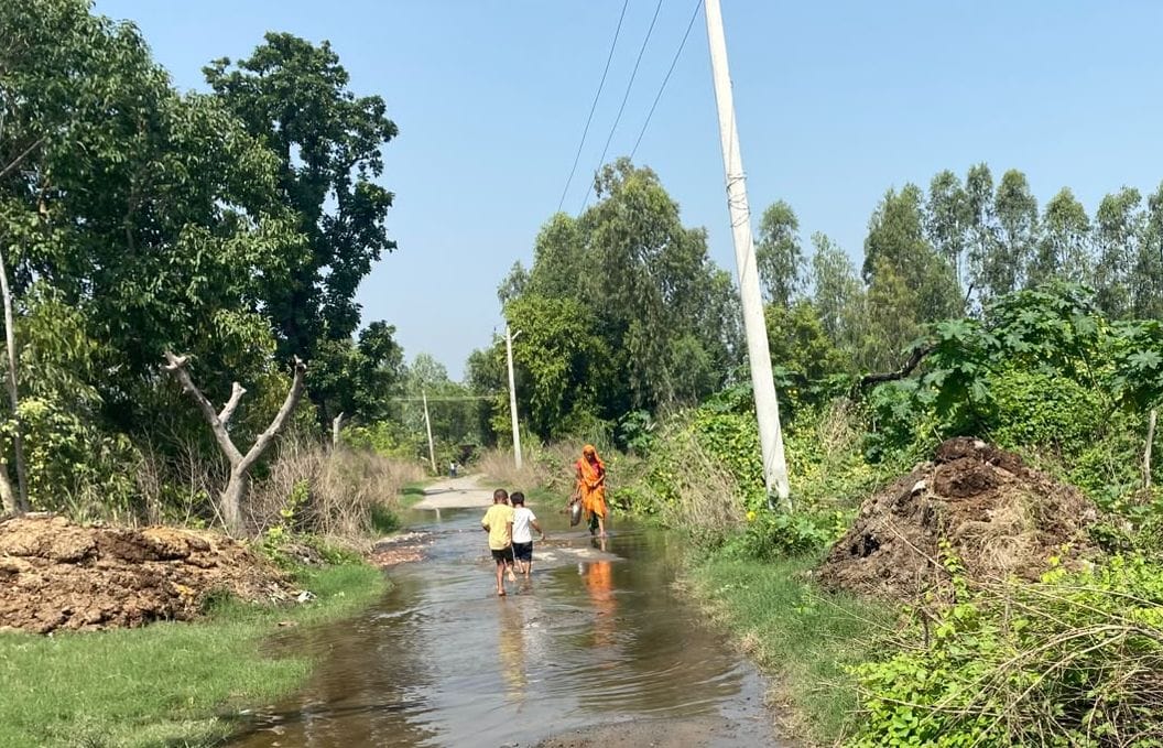 फोटो51पटियाली तहसील क्षेत्र के गांव नगला दुर्जन में सड़क पर बह रहे बाढ़ के पानी के बीच से निक