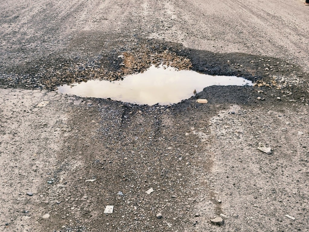 Prayagraj News: गड्ढे भरी सड़क में हिचकोले खा रहे राहगीर