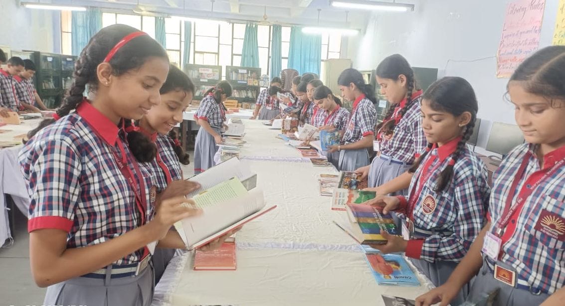 प्रदर्शनी में उपलब्ध पुस्तकों का अवलोक करतीं छात्राएं। स्रोत: शिक्षक
