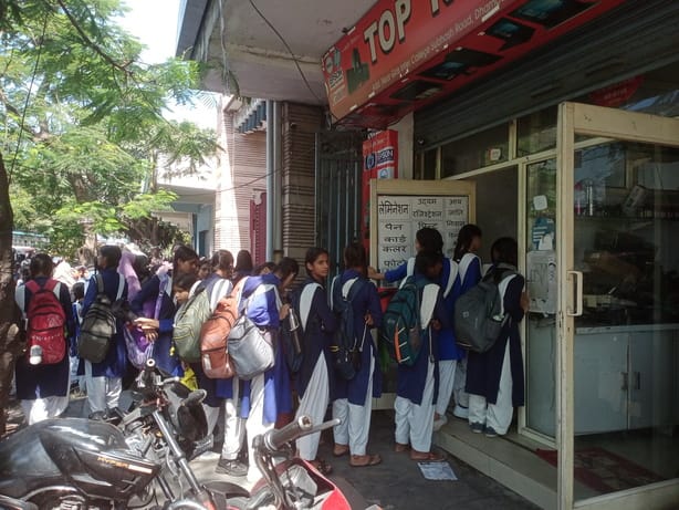 धामपुर में कन्या इंटर कॉलेज के बाहर जन सेवा केंद्र पर छात्रवृत्ति फॉर्म ऑनलाइन करने के लिए छात्