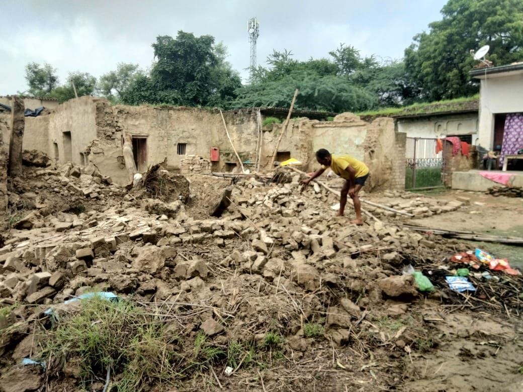 असोहा ब्लाक की ग्राम पंचायत पाठकपुर में गिरे कच्चे घर को दिखाता मोनू। स्रोत: आर्काइव