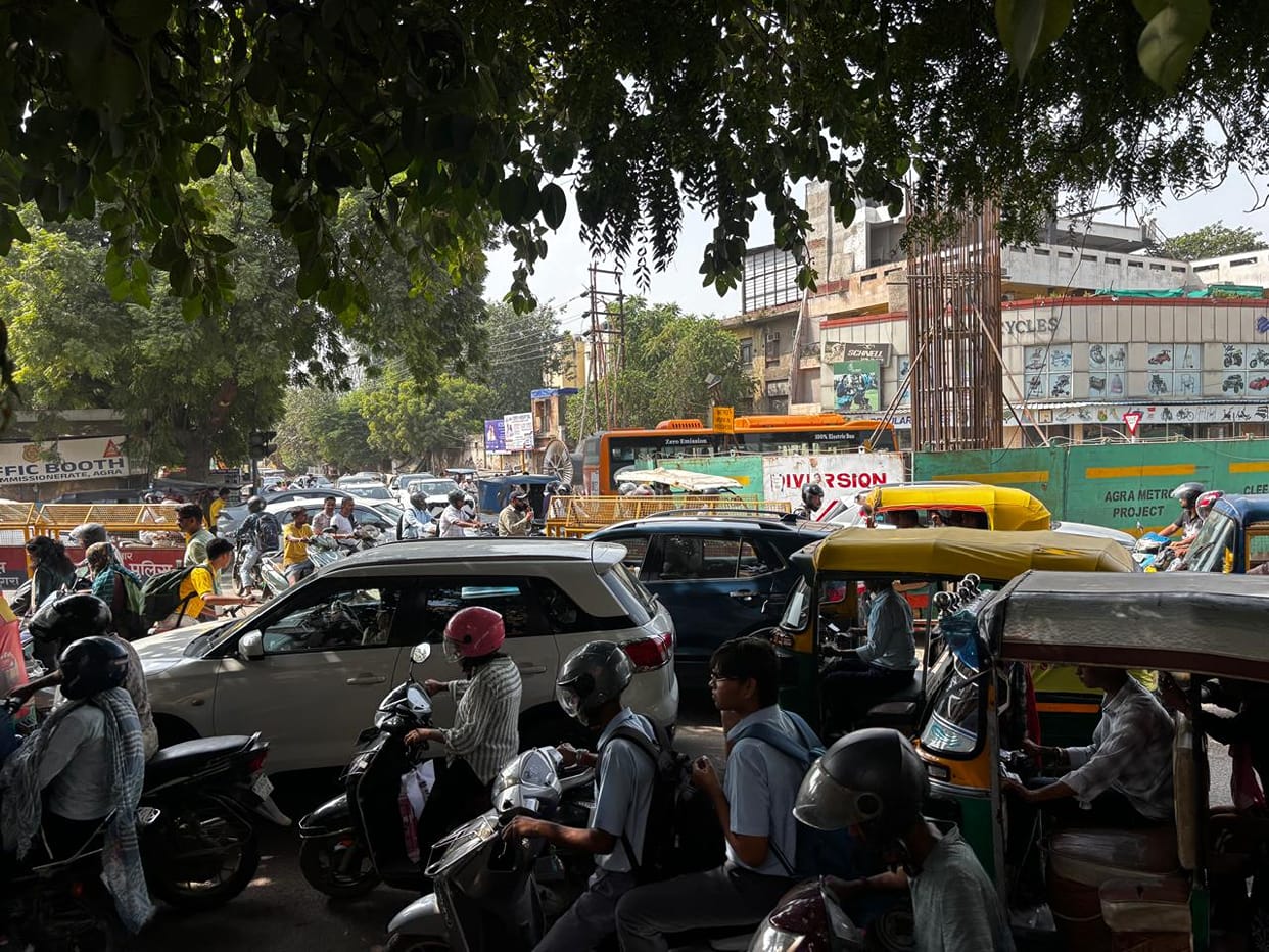 Road caves in due to broken sewer line; vehicles stuck, traffic jam ensues.