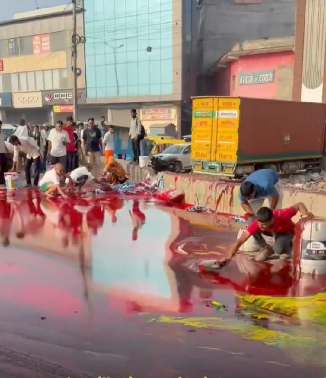 People rushed to grab paint spilled on the road.