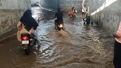 निगोही में रेलवे के अंडरपास में भरे पानी से गुजरते लोग। संवाद