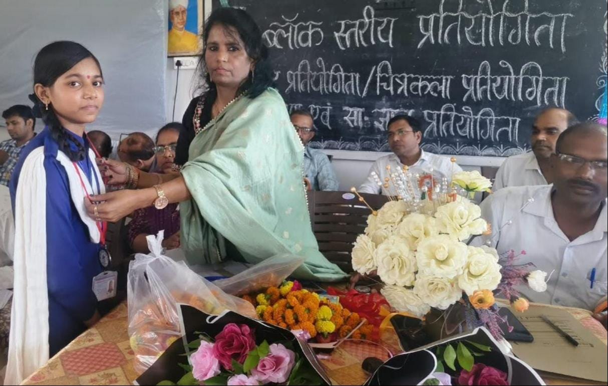 प्रतियोगिता की विजेता प्रतिभागी को मेडल पहनातीं प्रधानाचार्या। स्रोत: आयोजक