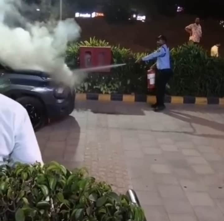 Fire breaks out in a car parked at Spaze Corporate Mall; guard extinguishes it.