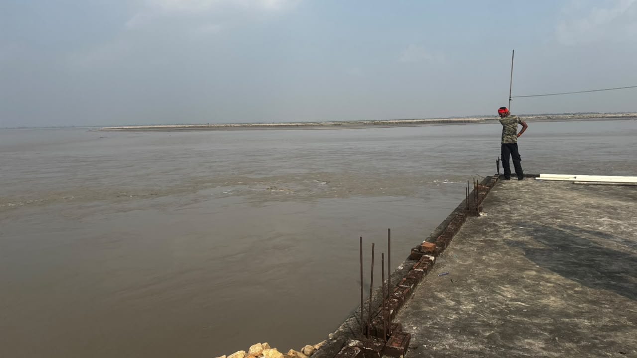 अहिरौली दान गांव के खैरखुटा टोला में कटान के जद में आने वाली घर के छत पर चढ़ कर देखता व्यक्ति।