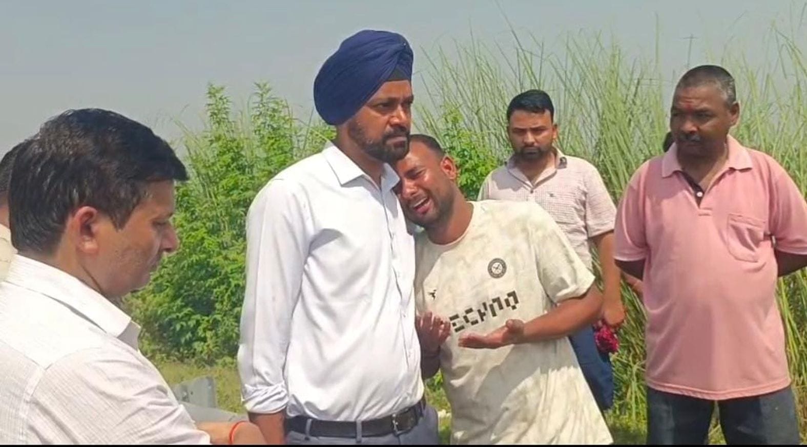 जिलाधिकारी से लिपट कर रोते परिजन। 