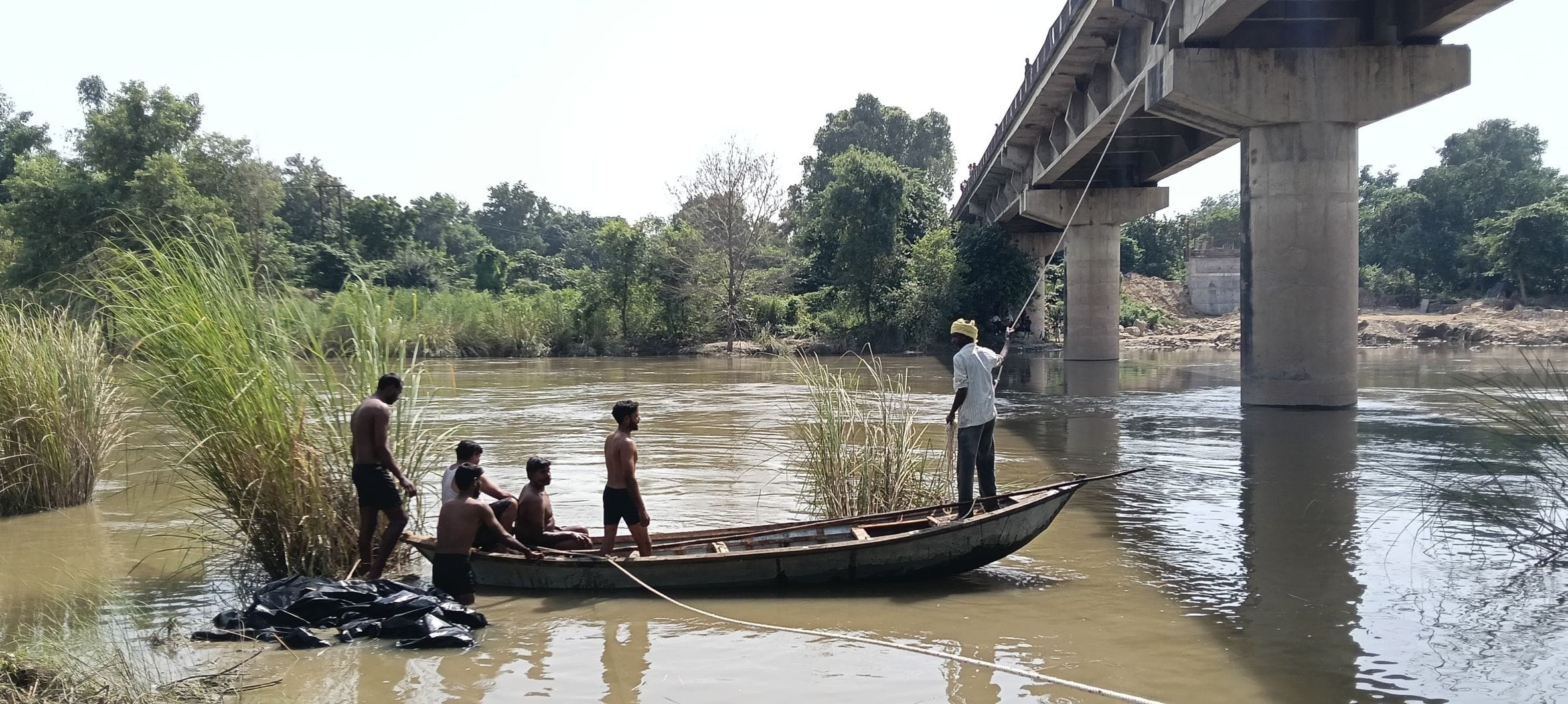 सई नदी में गिरे चीनी से लदे ट्रक की तलाश करते गोताखोर। 
