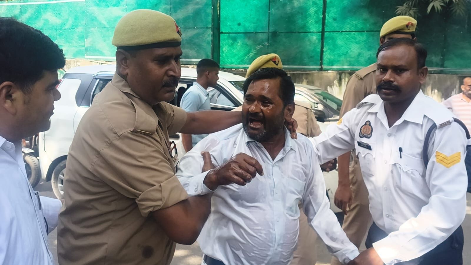 आत्मदाह का प्रयास करने वाले युवक को लेकर जाते पुलिस कर्मी। संवाद