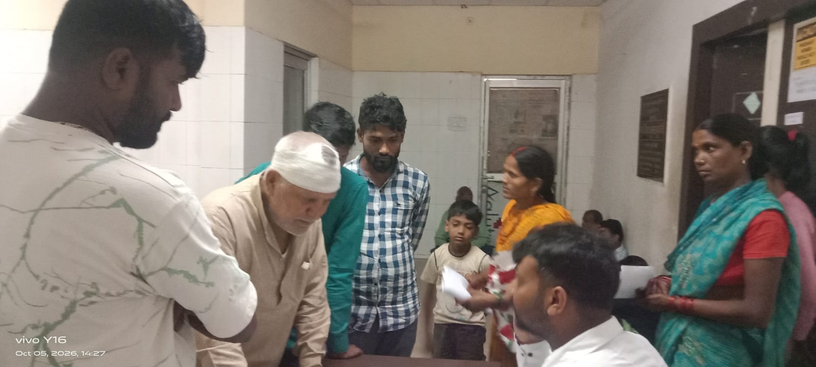 जांच कराने के लिए कुर्सी और फर्श पर बैठकर इंतजार करते मरीज और तीमारदार।