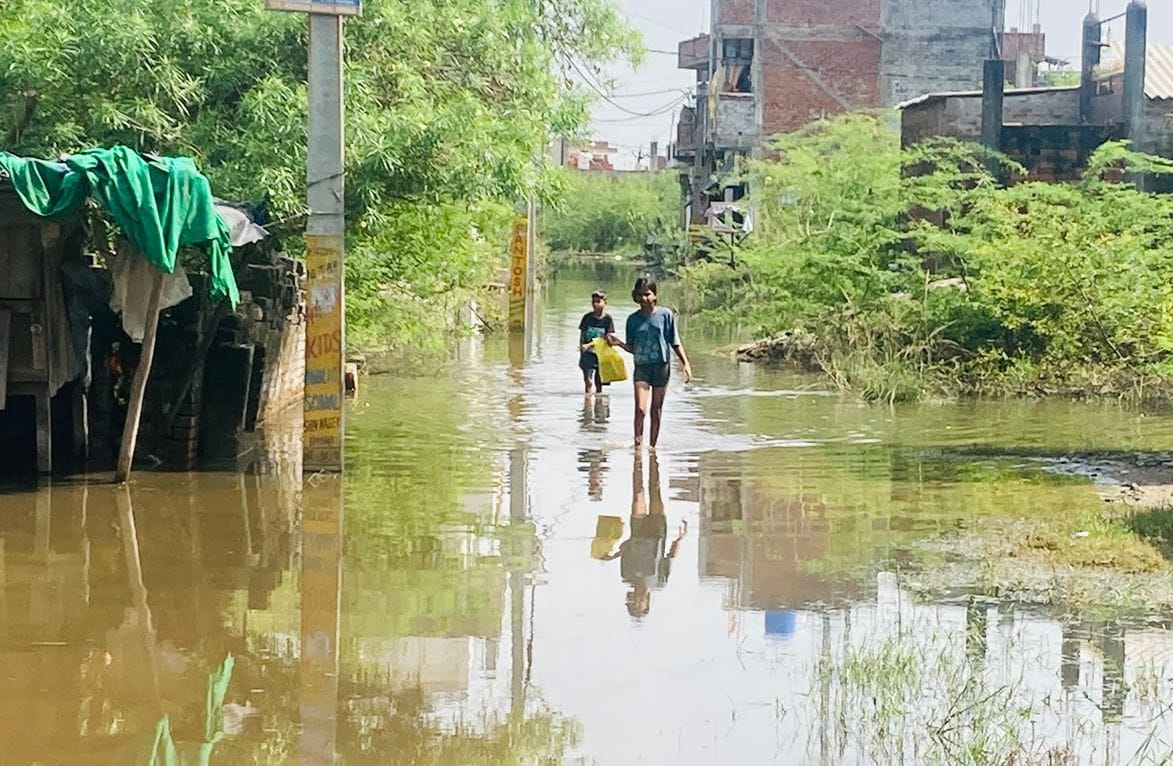 पानी से होकर जाती बच्ची। संवाद