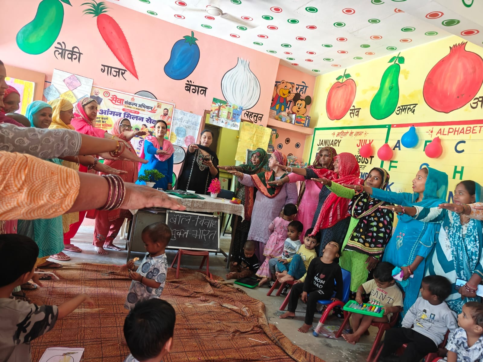 आंगन मिलन कार्यक्रम में भाग लेतीं महिलाएं व बच्चे। स्रोत : विभाग