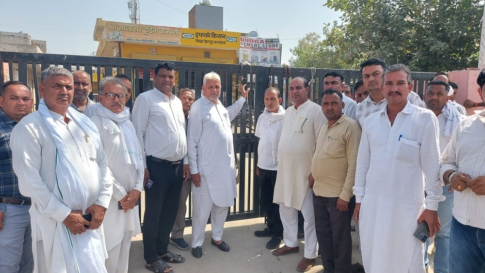 फोटो 2 नरवाना। नईं अनाज मेला मंडी के मुख्य गेट पर ताला लगाते हुए आढ़ती। संवाद।