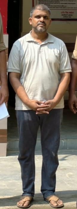 पुलिस हिरासत में एजेंट अमित चंद्र। स्रोत पुलिस
