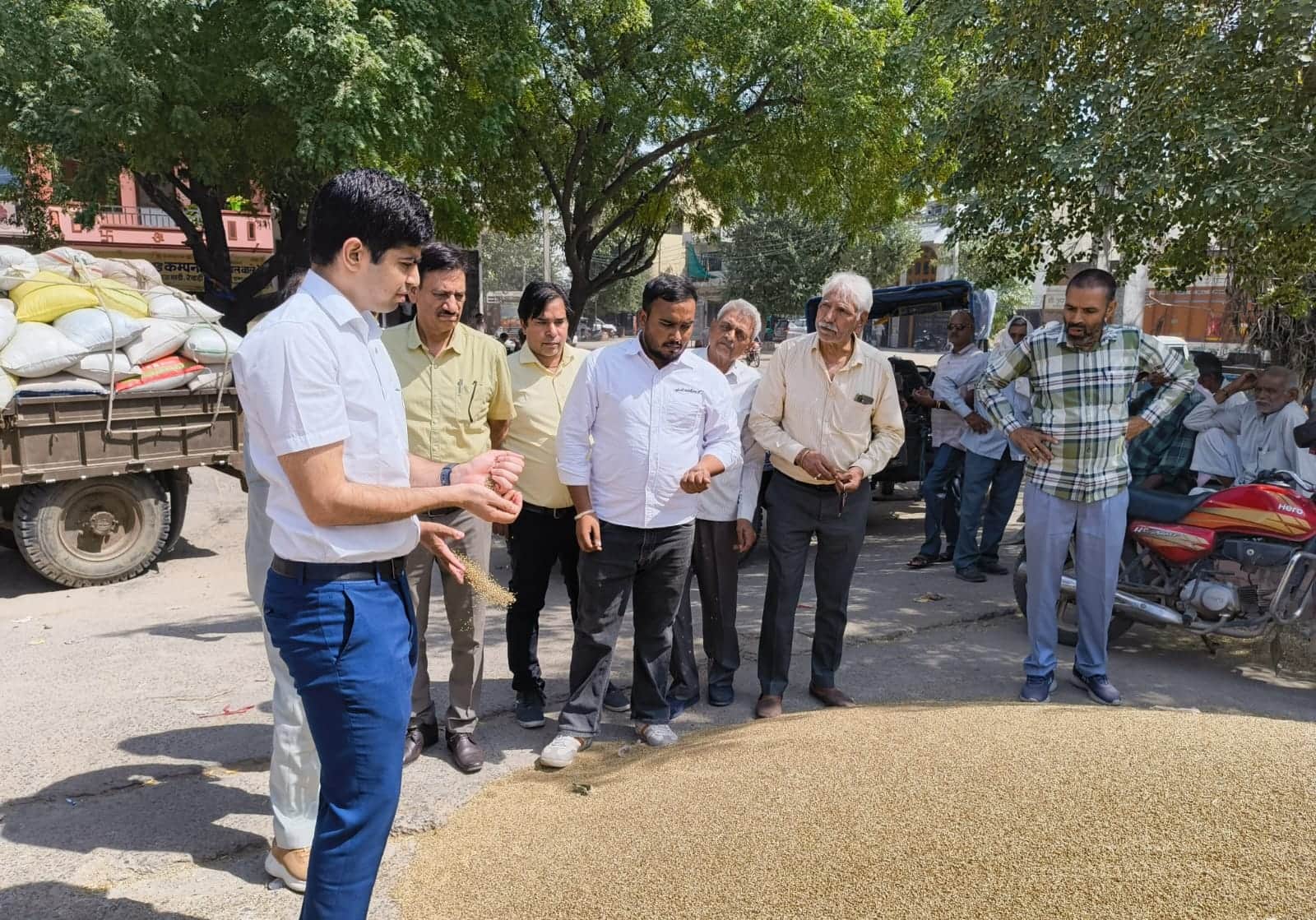 डीसी अभिषेक मीणा बाजरा की जांच करते। स्रोत : प्रशासन