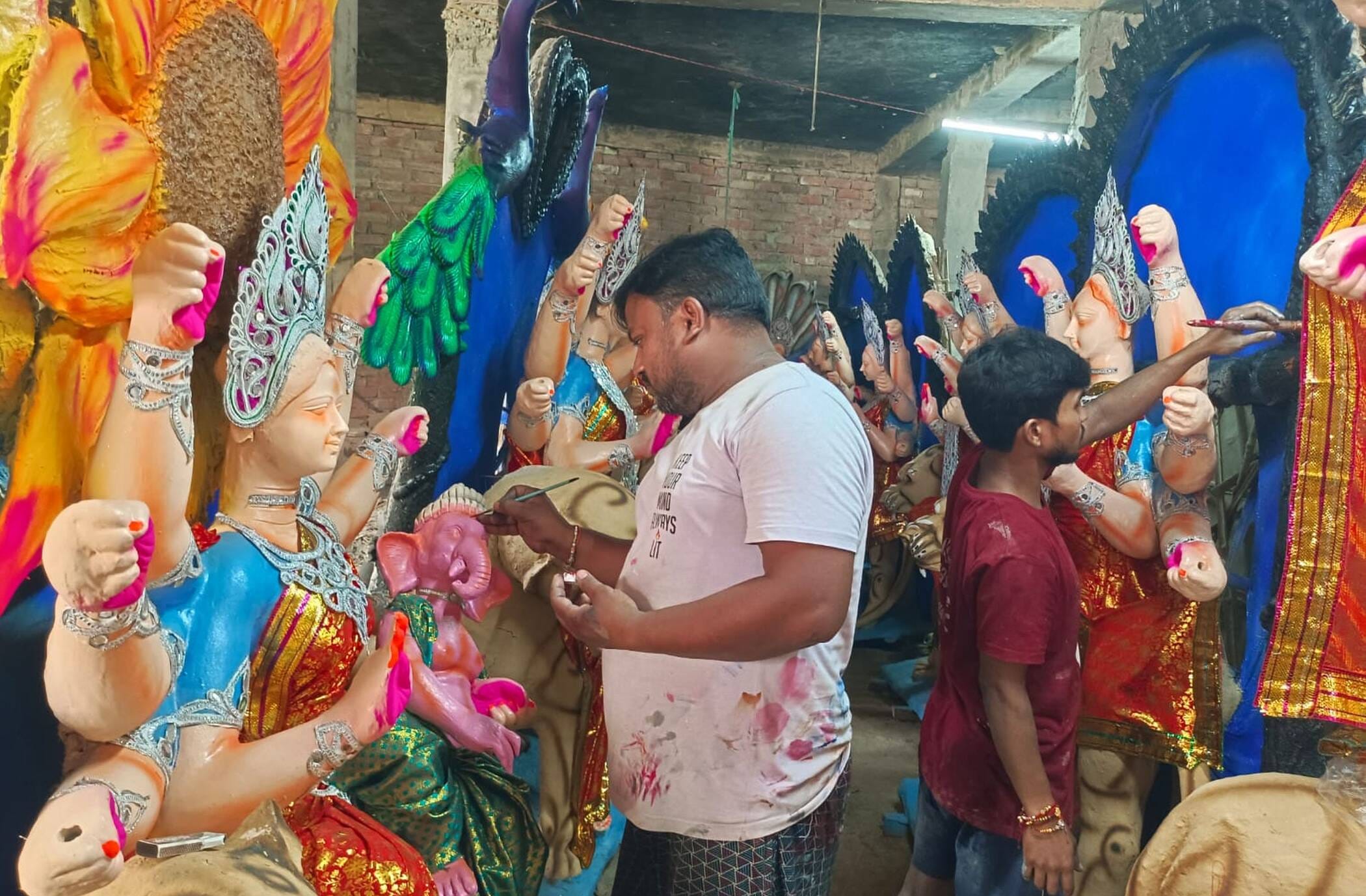 फोटो-10-शहर के खंभापुर में मां की प्रतिमा को अंतिम रूप देते मंजीत। संवाद