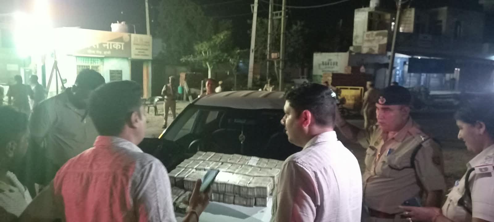 जांच के दौरान कार पर रखी बरामद डेढ़ करोड़ की राशि। स्रोत : पुलिस