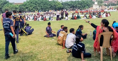 आर्य कॉलेज में आयोजित कार्यक्रम में बच्चों को धूप में बैठने के लिए कहती अध्यापिका। संवाद