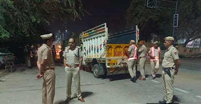रात को वाहनों की जांच करते हुए पुलिस कर्मचारी।