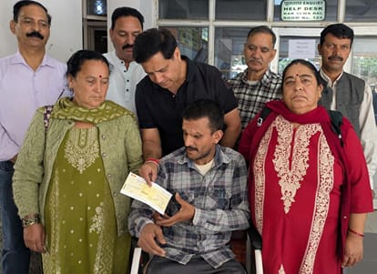 दिव्यांग रूम सिंह को 5,000 रूपये का चैक सौंपते कार सेवा के सदस्य। स्त्रोत कार सेवा