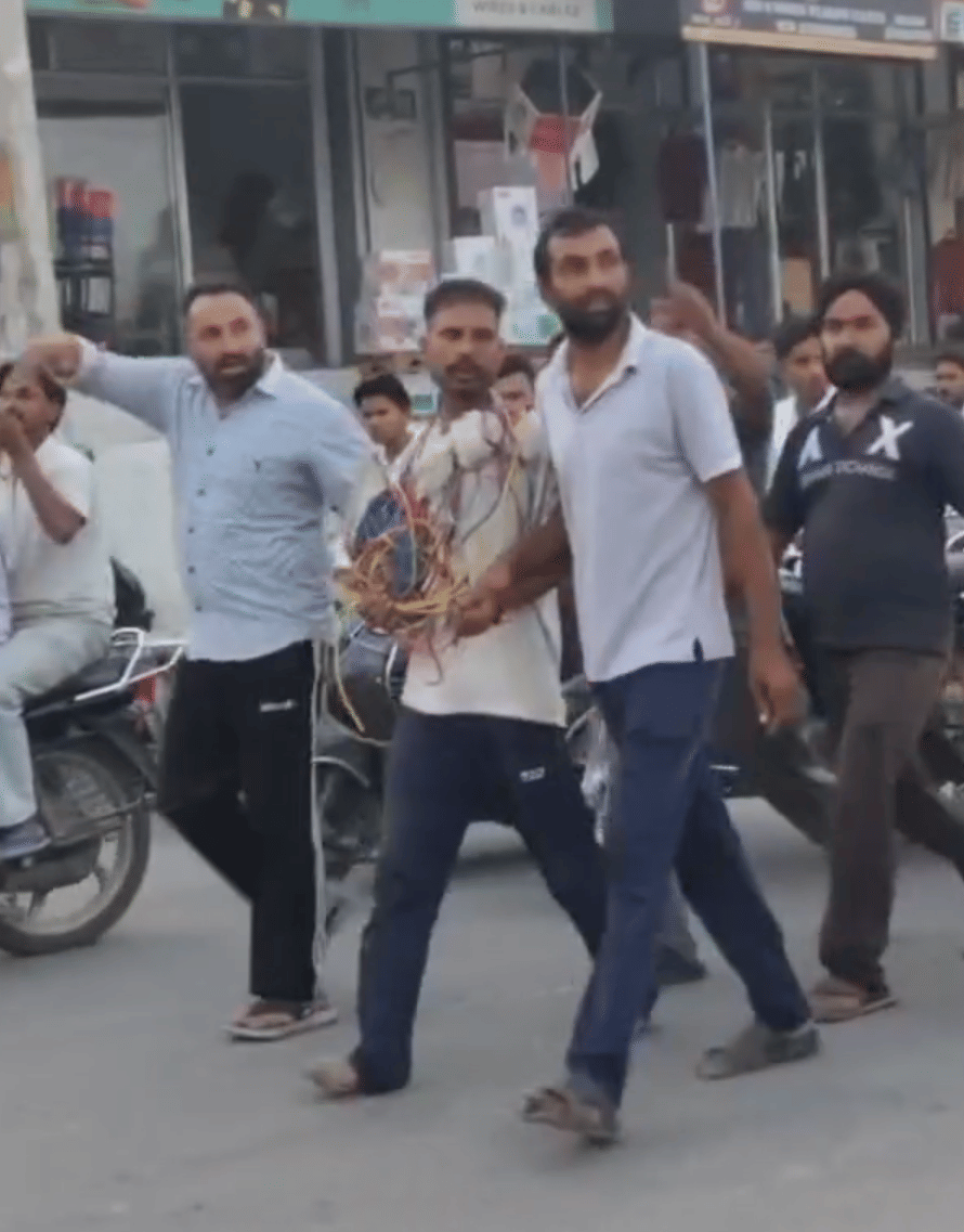 युवक के गले में चोरी के तार डाल कर घुमाते ग्रामीण। सोशल मीडिया