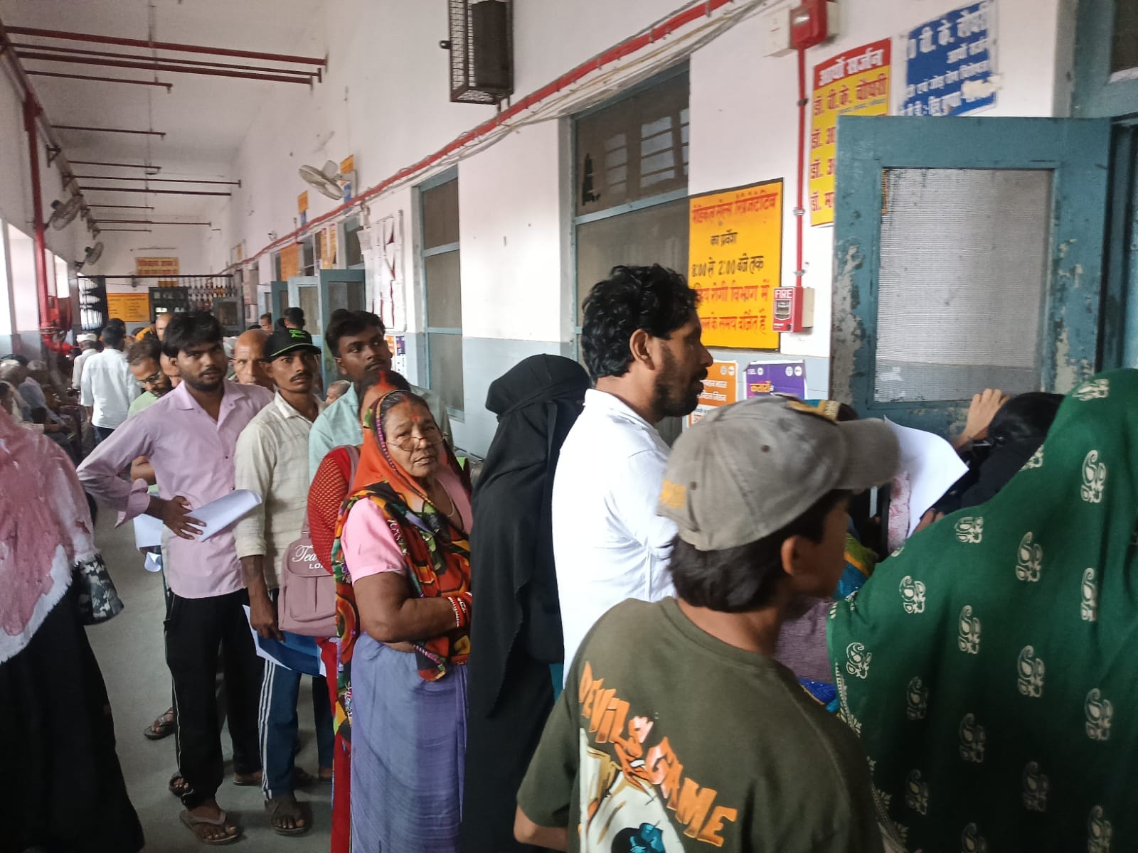 डॉक्टर को दिखाने के लिए अपनी बारी का इंतजार करते मरीज।