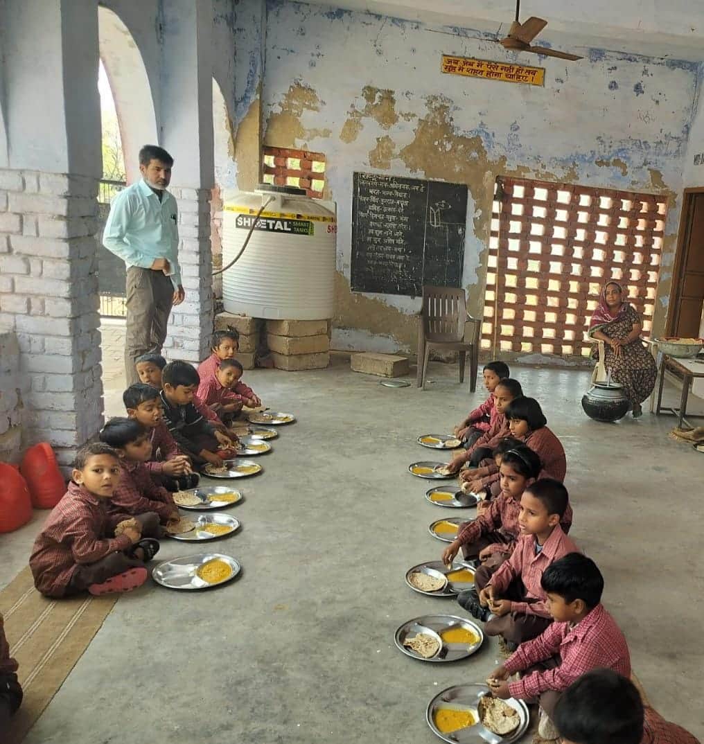मिड-डे मील के दौरान दोपहर का भोजन करते छोटे बच्चे। संवाद 
