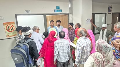शहर के मेडिकल कॉलेज में  चिकित्सक कक्ष के बाहर गेट पर खड़ा कर्मचारी। 