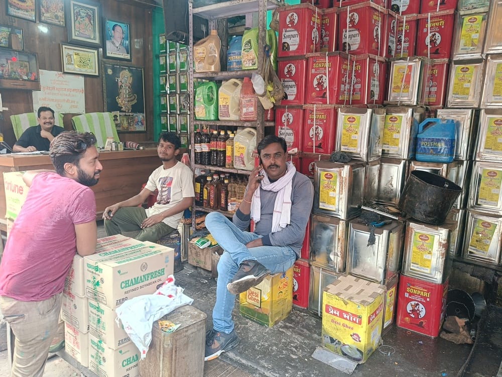 शहर में एक दुकान पर रखे तेल के टिन। संवाद