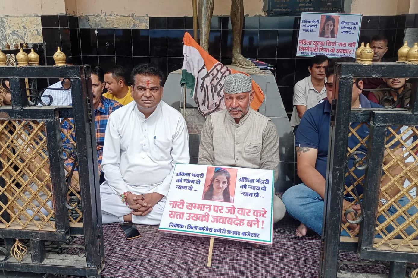 बागेश्वर में गांधी प्रतिमा के नीचे धरने पर बैठे कांग्रेसी। संवाद