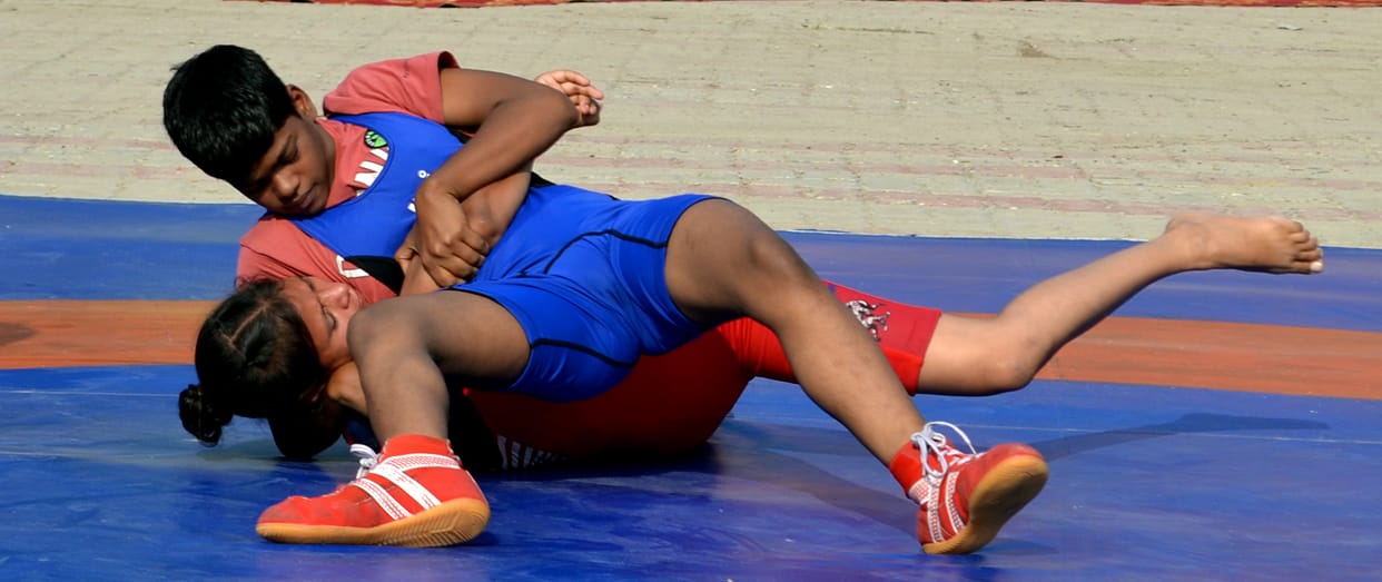 The wrestling action begins; female wrestlers showcase their strength